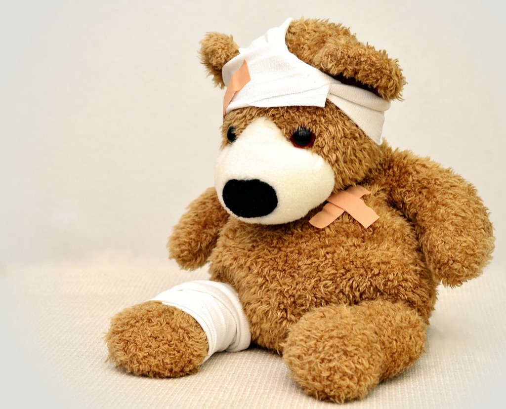 Verbundener Teddybär mit Pflaster als Sinnbild für Erste Hilfe
