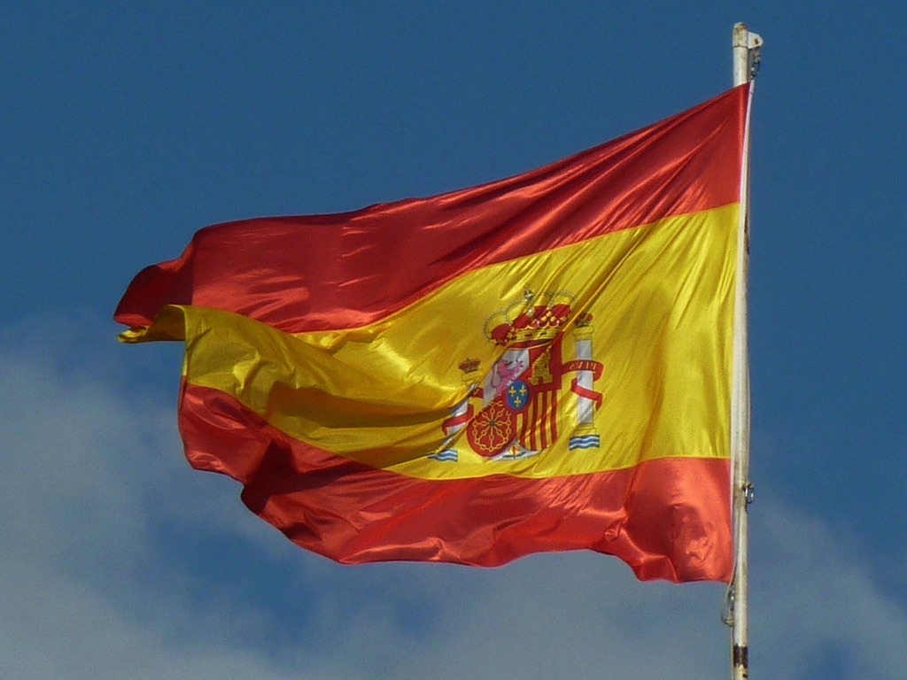 Spanische Flagge weht vor blauem Himmel