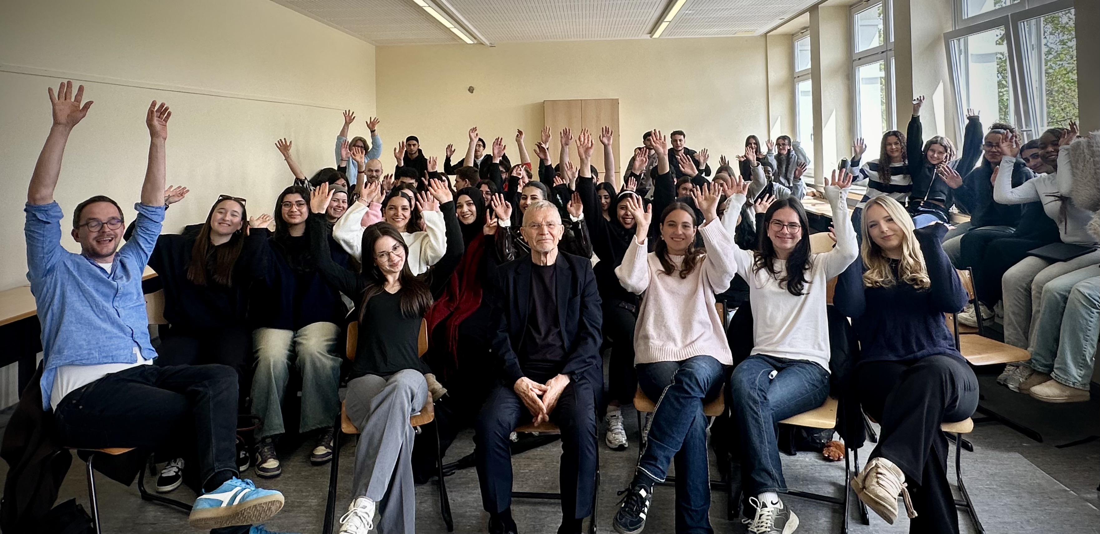 Prof. Dr. Klaus Hurrelmann sitzt mit Schülerinnen und Schülern der Q1-Pädagogikkurse im Klassenraum