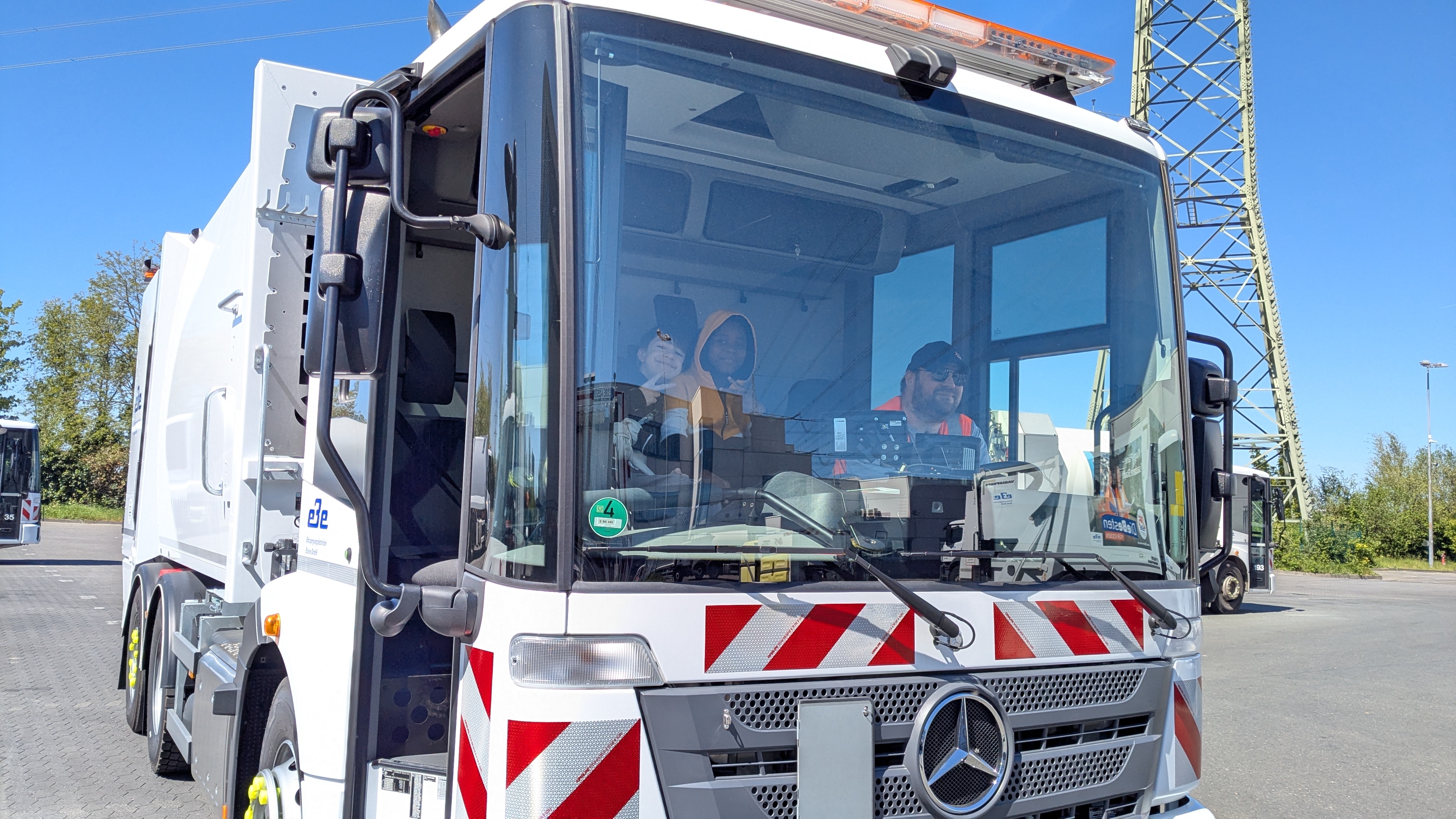 Teilnehmergruppen der SauberZauber-Aktion vor einem Entsorgungsfahrzeug der EBE